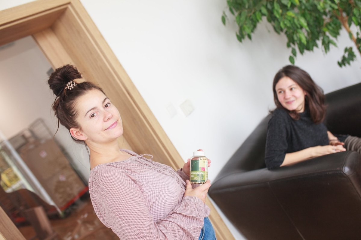 Kobieta trzymająca opakowanie ashwagandhy w dłoniach
