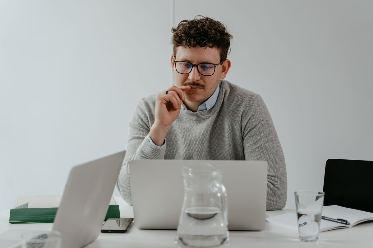 Mężczyzna siedzący przy laptopie i skupiony na pracy